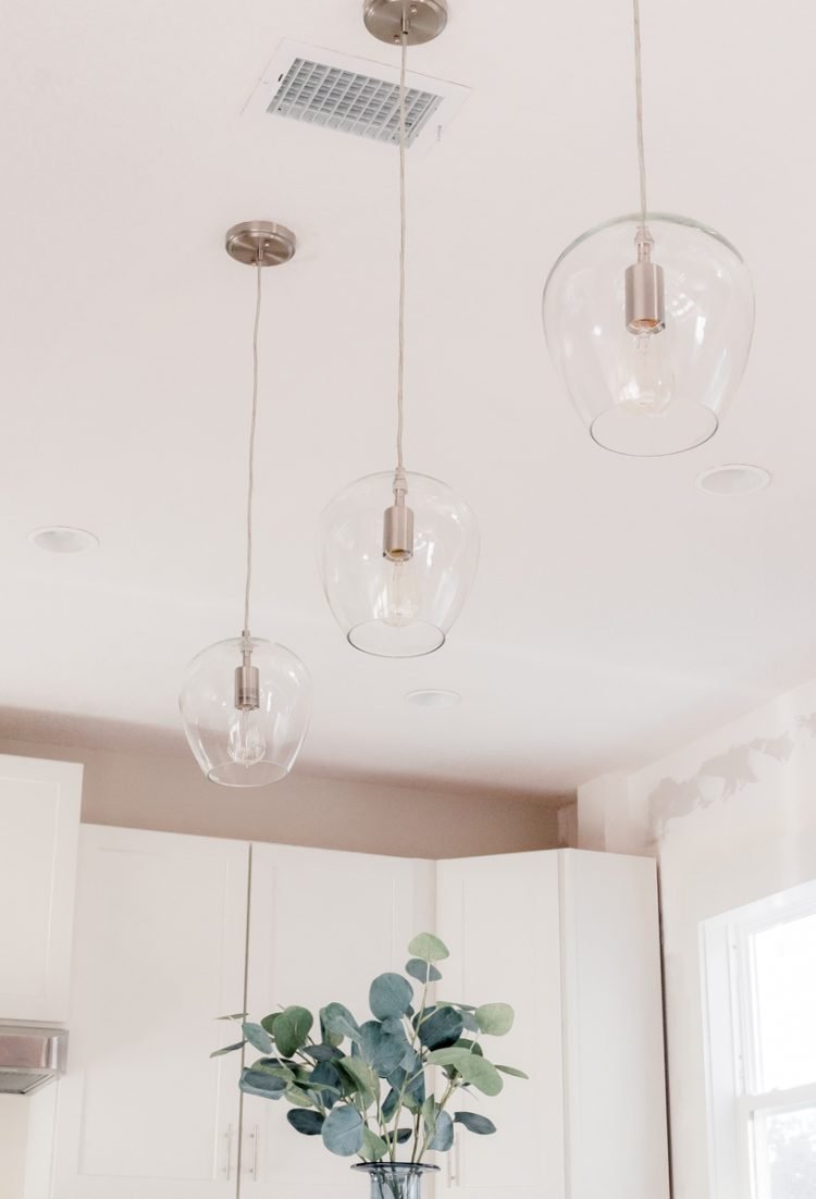 three glass pendants over island