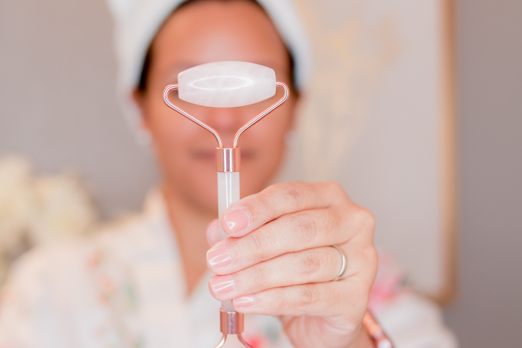 woman holding a rose quartz roller