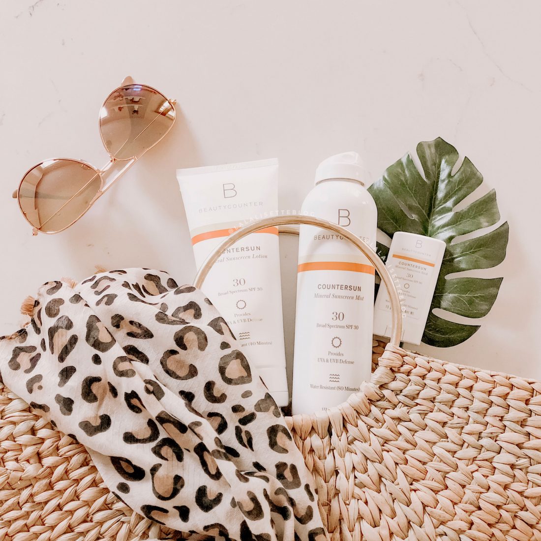 Beautycounter Countersun mineral sunscreens with straw bag and sunglasses - Why We Switched to Mineral Sunscreen